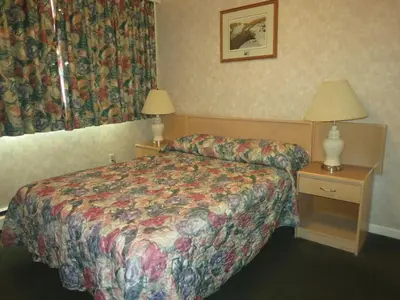 a hotel room with a bed and a table with a lamp at Tropicana Suite Hotel in Vancouver