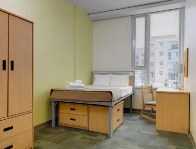 a bedroom with a bed and a desk and a window at University of Calgary Accommodations and Events in Calgary