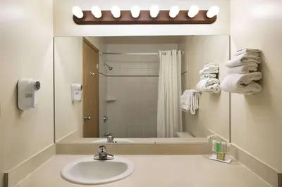 a bathroom with a sink and a mirror at Super 8 by Wyndham Slave Lake AB in Slave Lake