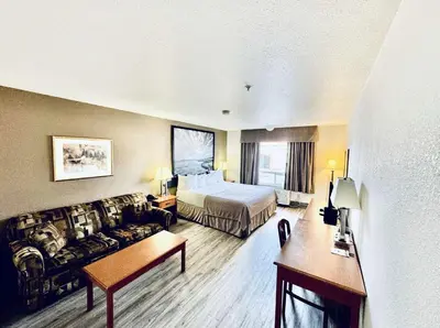 a hotel room with a bed and a couch at Super 8 by Wyndham Slave Lake AB in Slave Lake