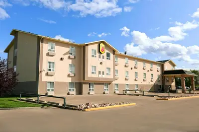 a hotel with a bunch of birds sitting outside of it at Super 8 by Wyndham Slave Lake AB in Slave Lake