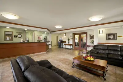 a living room with a couch and a table at Super 8 by Wyndham Slave Lake AB in Slave Lake