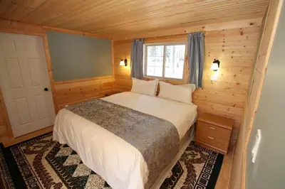 a bedroom with a bed in a wooden room at Glenogle Mountain Lodge and Spa in Golden