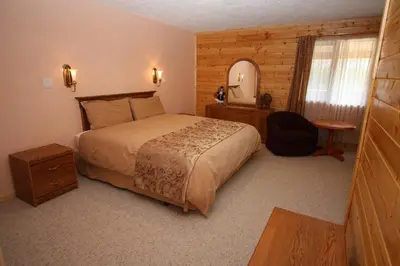 a bedroom with a large bed and a mirror at Glenogle Mountain Lodge and Spa in Golden