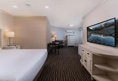 a hotel room with a bed and a desk at Prestige Beach House, WorldHotels Crafted in Kelowna