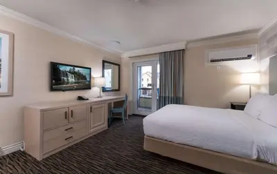 a hotel room with a bed and a desk and a television at Prestige Beach House, WorldHotels Crafted in Kelowna
