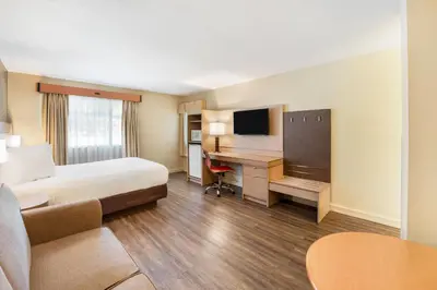 a hotel room with a bed and a desk at Days Inn by Wyndham Nanaimo in Nanaimo