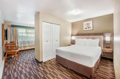 a bedroom with a bed and a desk and a chair at Days Inn by Wyndham Nanaimo in Nanaimo