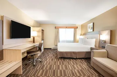 a hotel room with a bed and a desk with a computer at Days Inn by Wyndham Nanaimo in Nanaimo