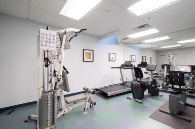a gym with several treadmills and exercise machines at Ocean Promenade Hotel in White Rock