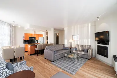 a living room with couches and a dining room at Ocean Promenade Hotel in White Rock