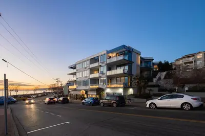 a city street with cars parked in front of a building at Ocean Promenade Hotel in White Rock