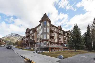 a large apartment building on the side of a street at Mountain View Escape with open hot tub, Views!! in Canmore