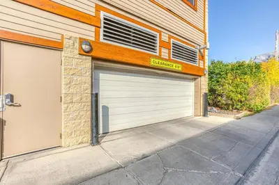 a garage with two garage doors on a building at RidgeView Loft - Top Floor 2 Bed 2 Bath, Amazing Views in Canmore