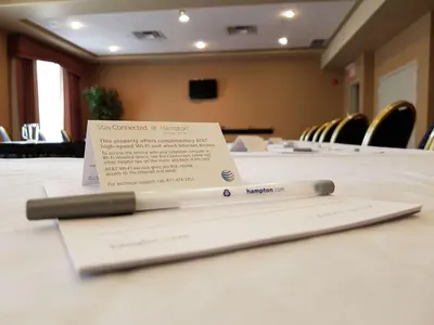 a sign sitting on top of a table in a conference room at Hampton Inn & Suites by Hilton Edmonton International Airport in Leduc
