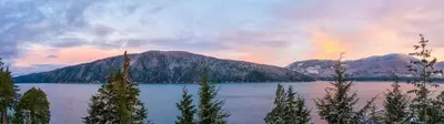 a rainbow in the sky over a lake with mountains at Bjørn Holm in Port Renfrew