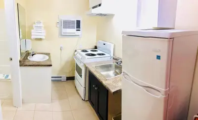 a small kitchen with a stove and a sink at Kings Motor Inn in Kamloops