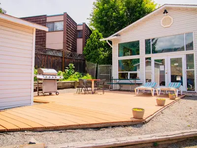 a backyard with a wooden deck next to a house at Kings Motor Inn in Kamloops