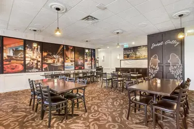 a restaurant with tables and chairs in a room at Days Inn by Wyndham Airdrie in Airdrie