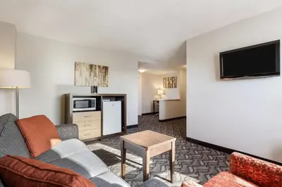 a living room with a couch and a tv at Days Inn by Wyndham Airdrie in Airdrie