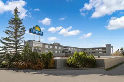 a hotel with a sign on top of a building at Days Inn by Wyndham Airdrie in Airdrie