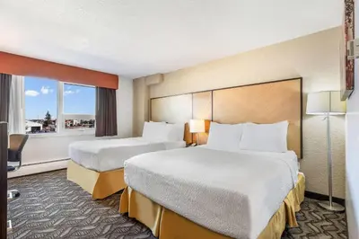 a hotel room with two beds and a window at Days Inn by Wyndham Airdrie in Airdrie