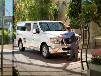 a man standing in front of a white truck at Chateau Victoria Hotel & Suites in Victoria