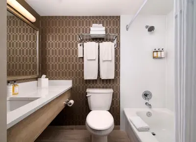 a bathroom with a toilet and a sink and a tub at Chateau Victoria Hotel & Suites in Victoria
