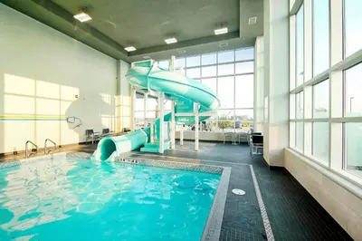 a large pool with a water slide in a building at Holiday Inn Hotel & Suites - Calgary Airport North by IHG in Calgary