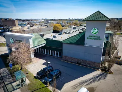 an aerial view of a building with cars parked outside at Amenida Residences, Calgary in Calgary