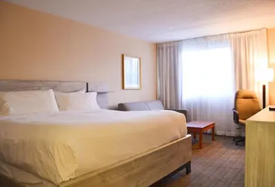 a hotel room with a large bed and a window at Amenida Residences, Calgary in Calgary