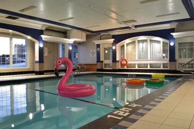 a swimming pool with a pink swan in the water at Amenida Residences, Calgary in Calgary