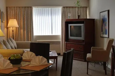 a living room with a couch and a tv at Rosellen Suites at Stanley Park in Vancouver