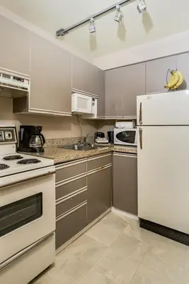 a kitchen with white appliances and a white refrigerator at Rosellen Suites at Stanley Park in Vancouver