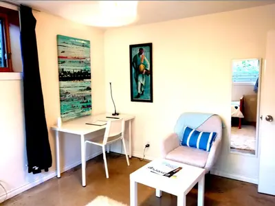 a living room with a desk and a chair at U of A Homestay, Trails & Whyte Ave in Edmonton
