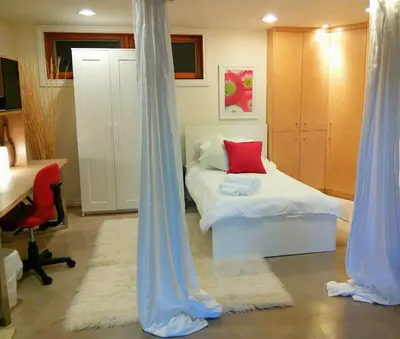 a bedroom with a bed with blue drapes at U of A Homestay, Trails & Whyte Ave in Edmonton