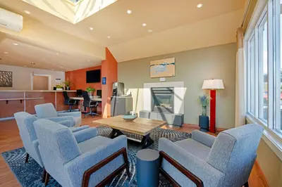 a living room with blue chairs and a table at Best Western Plus Emerald Isle Hotel in Sidney