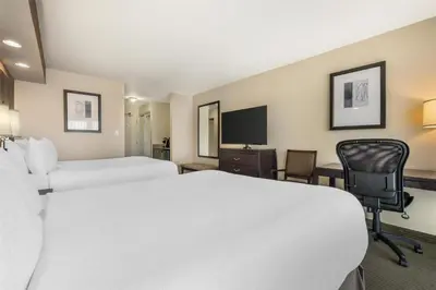 a hotel room with two beds and a desk and a tv at Best Western The Westerly Hotel in Courtenay