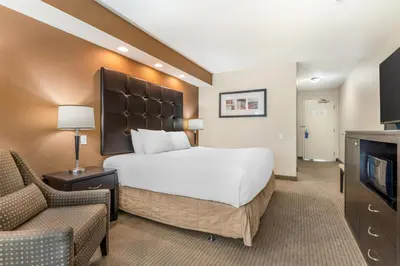 a hotel room with a bed and a couch and a tv at Best Western The Westerly Hotel in Courtenay