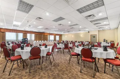 a banquet hall with white tables and red chairs at Best Western The Westerly Hotel in Courtenay