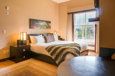 a bedroom with a bed and a large window at Silver Creek Lodge in Canmore