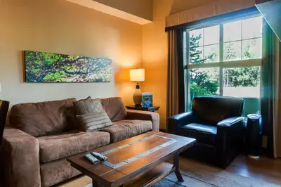 a living room with a couch and a chair at Silver Creek Lodge in Canmore