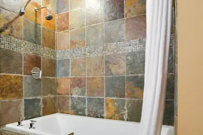 a bathroom with a tub and a shower curtain at Silver Creek Lodge in Canmore