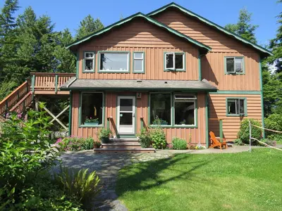 a wooden house with a porch and a deck at Summerhill Guest House in Tofino