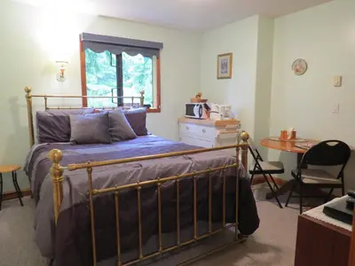 a bedroom with a bed and a desk and a table at Summerhill Guest House in Tofino