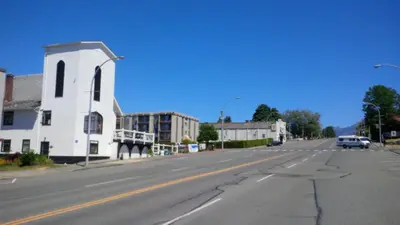 an empty street in a small town with a white building at Char's Landing Hostel in Port Alberni