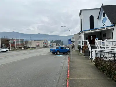 a blue truck parked on the side of a street at Char's Landing Hostel in Port Alberni