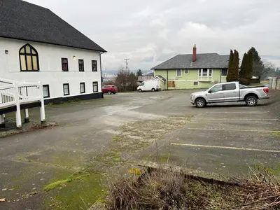 a car parked in a parking lot next to a building at Char's Landing Hostel in Port Alberni