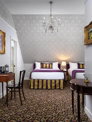 a bedroom with two beds and a chandelier at Pendray Inn and Tea House in Victoria