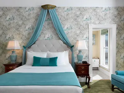 a bedroom with a bed with a blue canopy at Pendray Inn and Tea House in Victoria